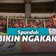 Suporter membawa spanduk kocak untuk semangati tim